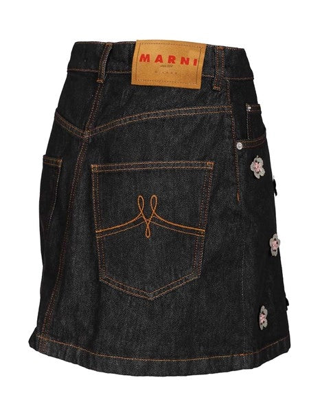Gonna in denim nero con applicazioni a forma di margherita