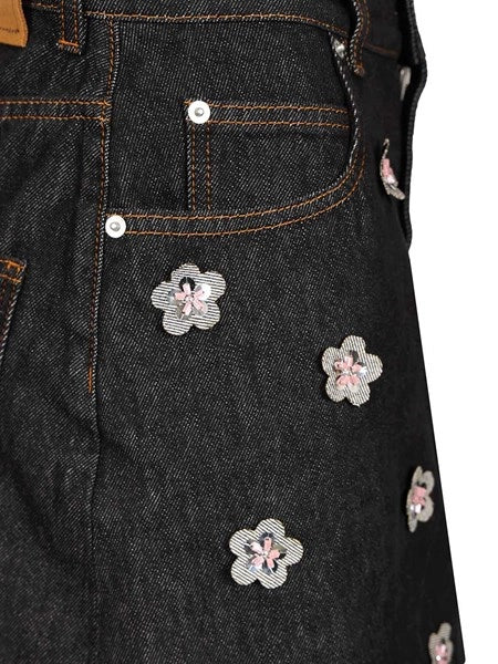 Gonna in denim nero con applicazioni a forma di margherita