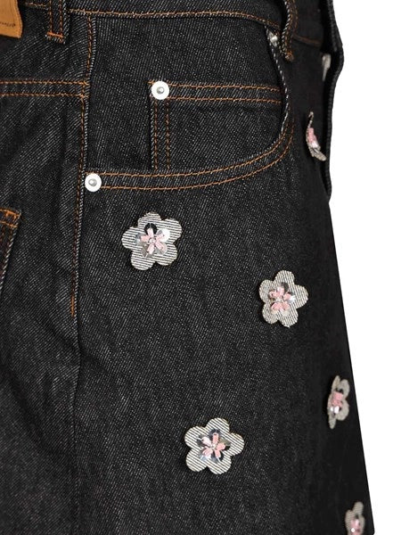 Gonna in denim nero con applicazioni a forma di margherita