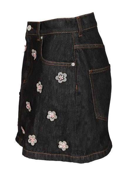 Gonna in denim nero con applicazioni a forma di margherita