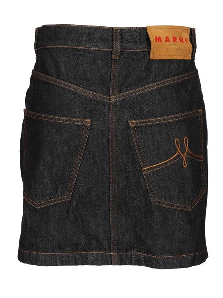 Gonna in denim nero con applicazioni a forma di margherita