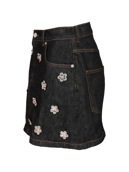 Gonna in denim nero con applicazioni a forma di margherita